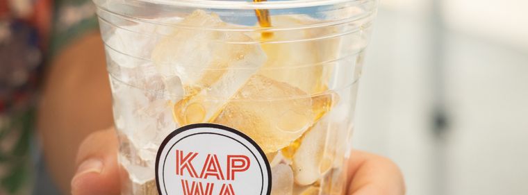 Cold brew pouring into a Kapwa cup over ube